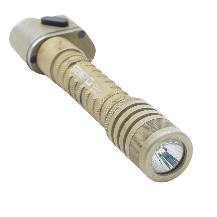 Taktische Taschenlampe mit sandfarbenem Gehäuse und sichtbarem Markenlogo auf weißem Hintergrund