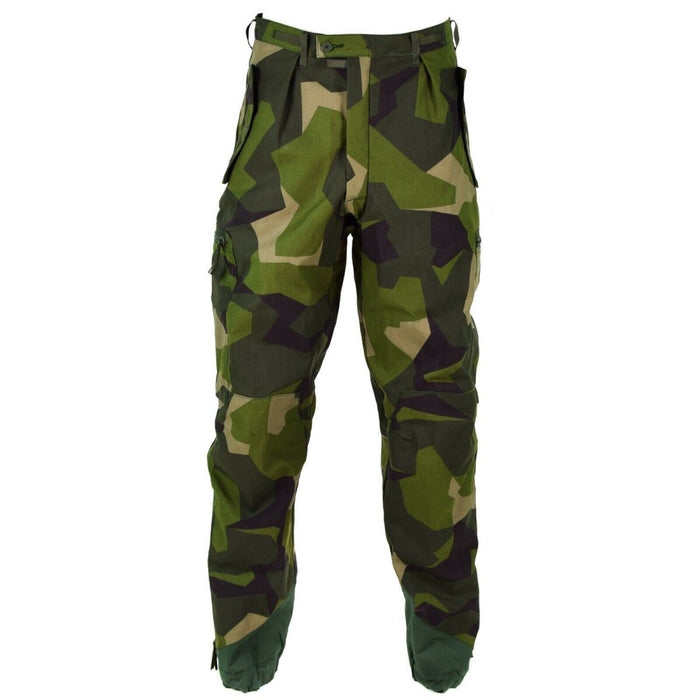 Pantalon M90 original de l'armée suédoise en camouflage éclaté avec genoux renforcés, fermetures éclair aux chevilles et fermetures de poches sécurisées pour plus de durabilité.