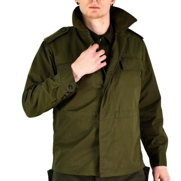 Uomo che indossa un'originale giacca da campo militare verde oliva ceca M85 vintage con polsini e spalline abbottonati