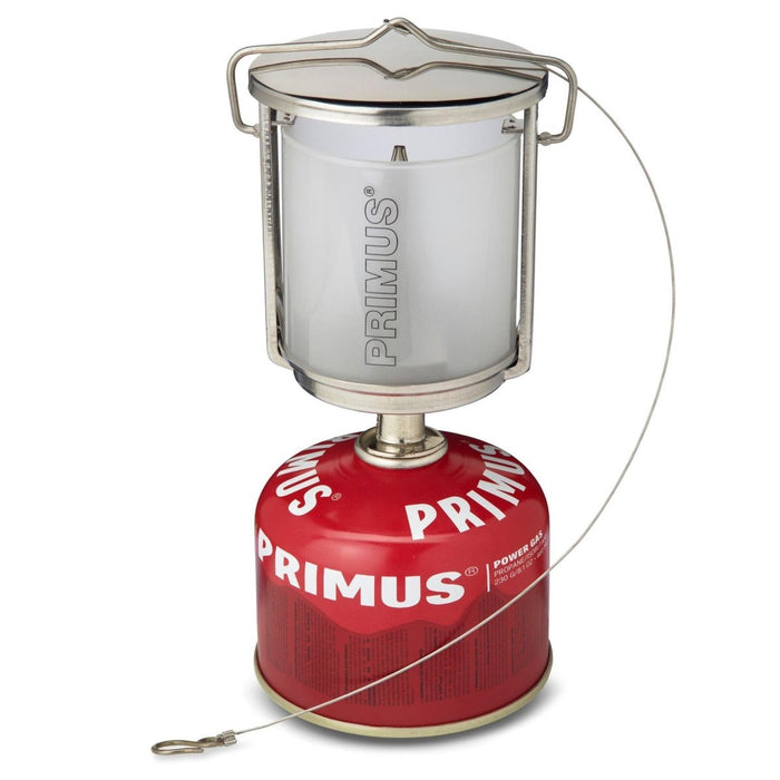 Tragbare Campinglaterne Primus Mimer mit Edelstahlgehäuse und Milchglas auf rotem Gasbrennstoffkanister.