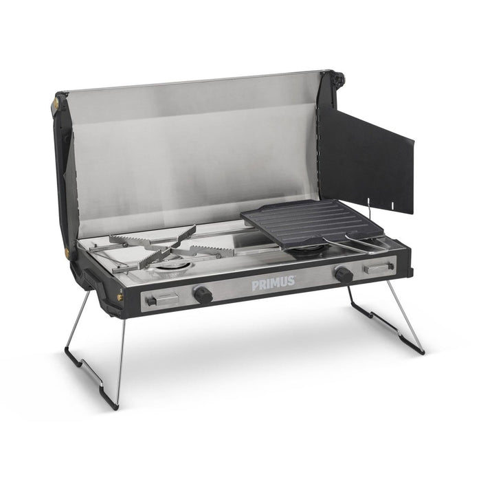 Primus Tupike dual gas burner outdoor camping stove with foldable legs and non-stick griddle plate for versatile cooking.